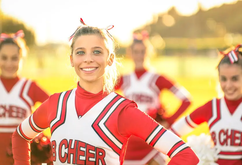 Portrait of an happy young cheerleader in action outdoors - Grou